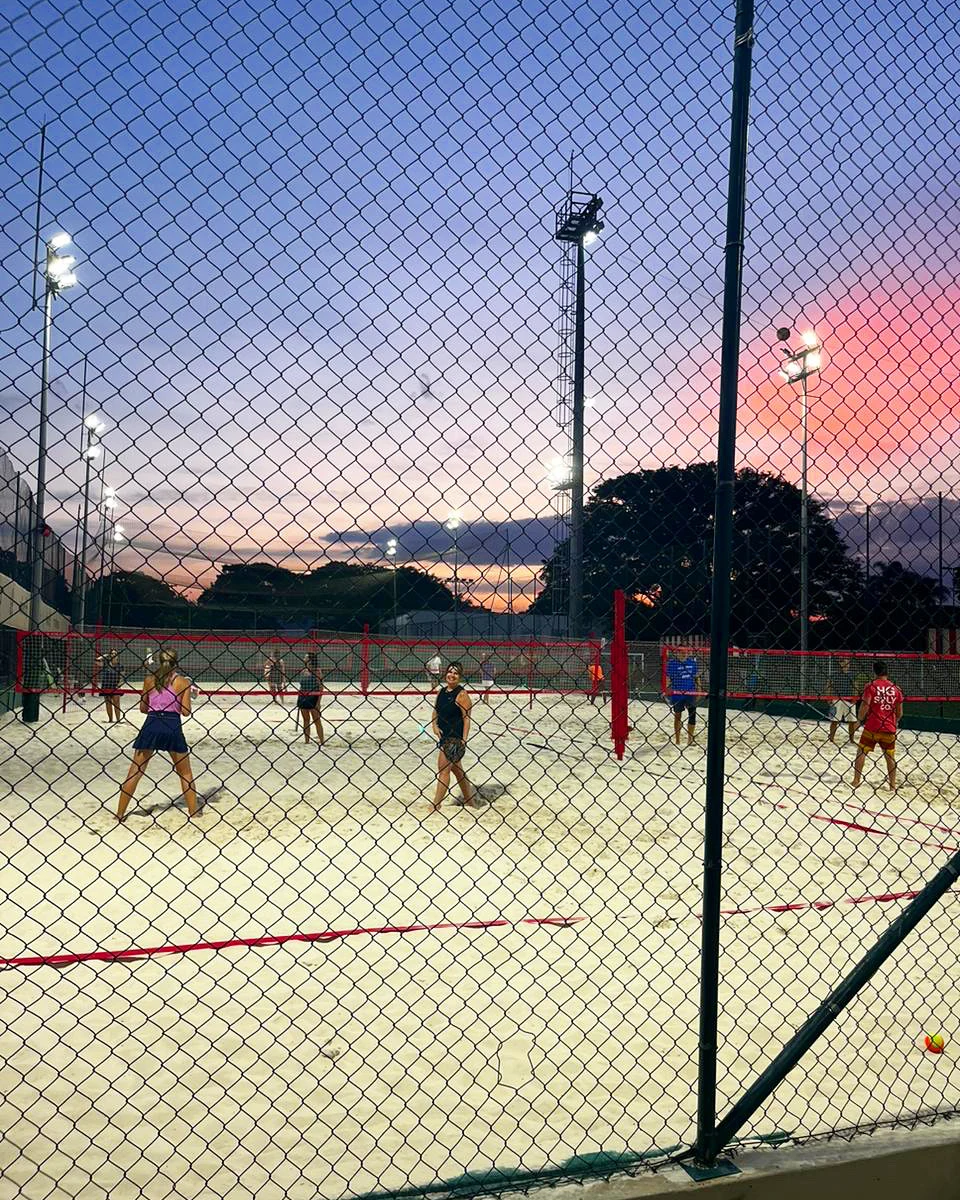 Quadras de Beach Tennis do Paulistano ao entardecer, com redes e associados jogando